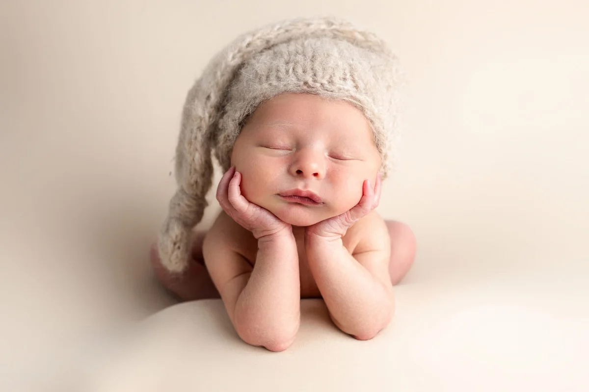 Newborn baby in classic froggy pose with grey knitted hat, professional newborn photography Hartlepool